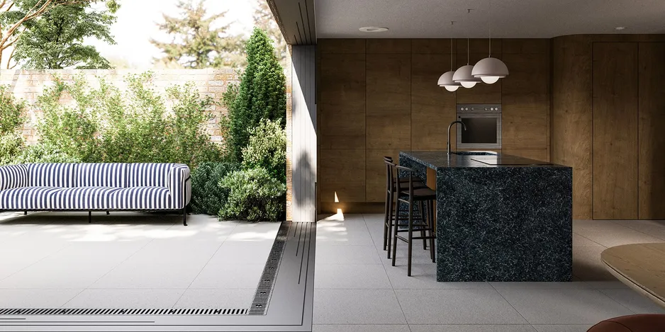 Kitchen with wide open patio door, warm wooden cabinets, green stone island, and an outdoor sofa in white and blue stripes.