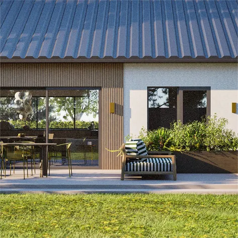 A single-storey modern house with a metal roof and vertical wooden cladding, featuring a patio area with a dining table and chairs, complemented by greenery and natural landscaping.