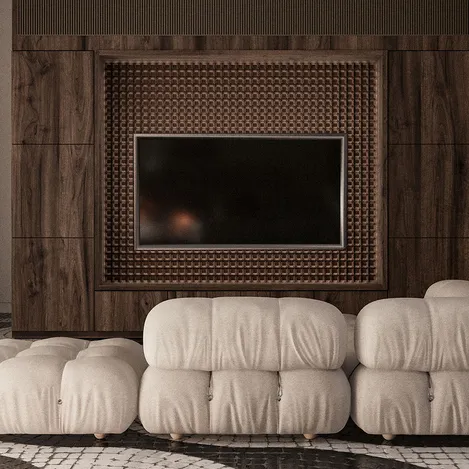 A tv wall mounted on an oak panel in the center of room with two large cream colored couches, with a textured grid patterned brown wood panels behind it.