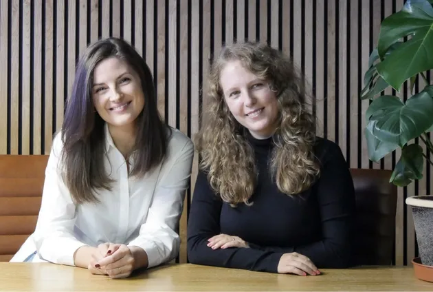 This photograph of Kasia and Marzena laughing together and sitting at the desk.